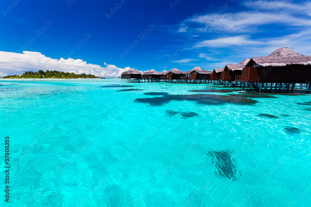 Overwater bungallows in blue tropical lagoon