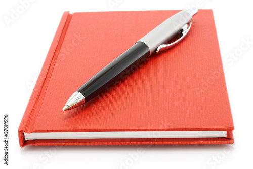 Red notepad with ball pen on a white background