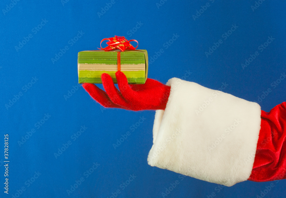 Santa's hand holding a present over blue background