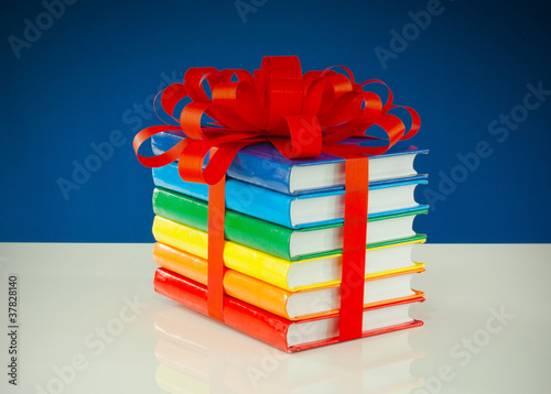 Obraz na płótnie Stack of colorful books tied up with red ribbon w salonie