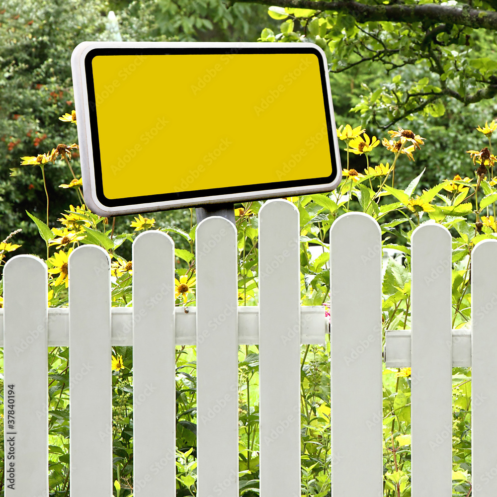 Gelbes Schild am Gartenzaun Gelbes Schild am Gartenzaun
