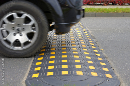 Speed bump on a road when and car photo