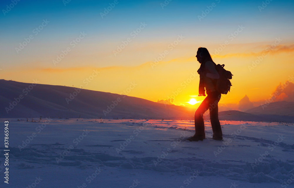 Woman traveler hiking in winter mountains