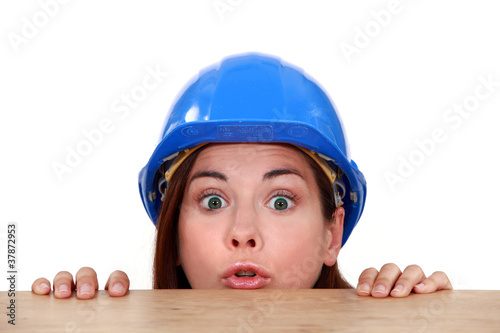 Slika na platnu Female builder peering over ledge