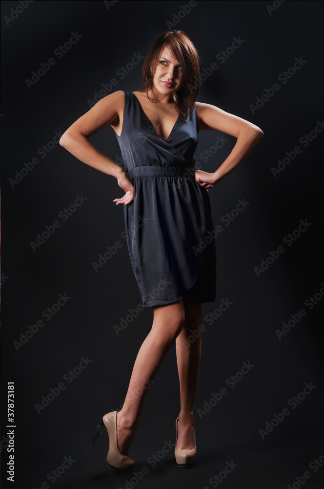 brunette girl posing in studio on dark background brunette girl posing in studio on dark background