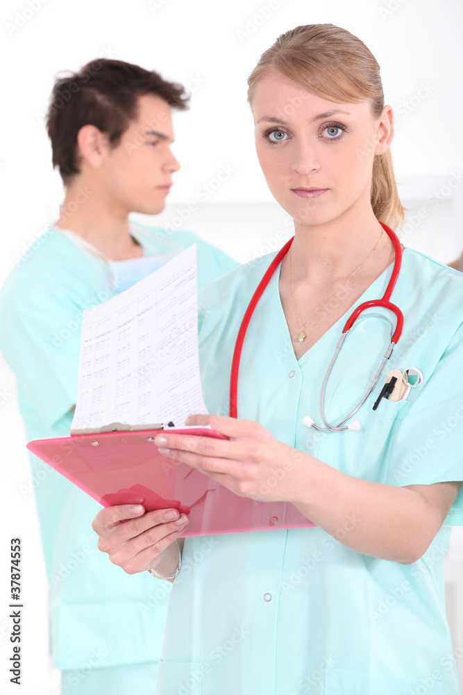 A medical professional checking her clipboard A medical professional checking her clipboard