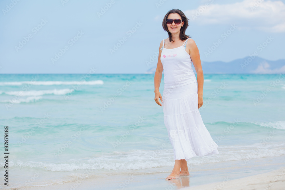 young woman walking near blue sea.