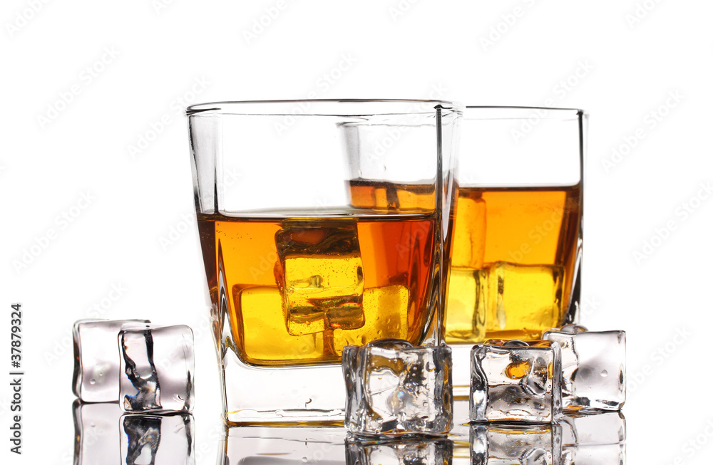 two glasses of scotch whiskey and ice on table isolated on white two glasses of scotch whiskey and ice on table isolated on white