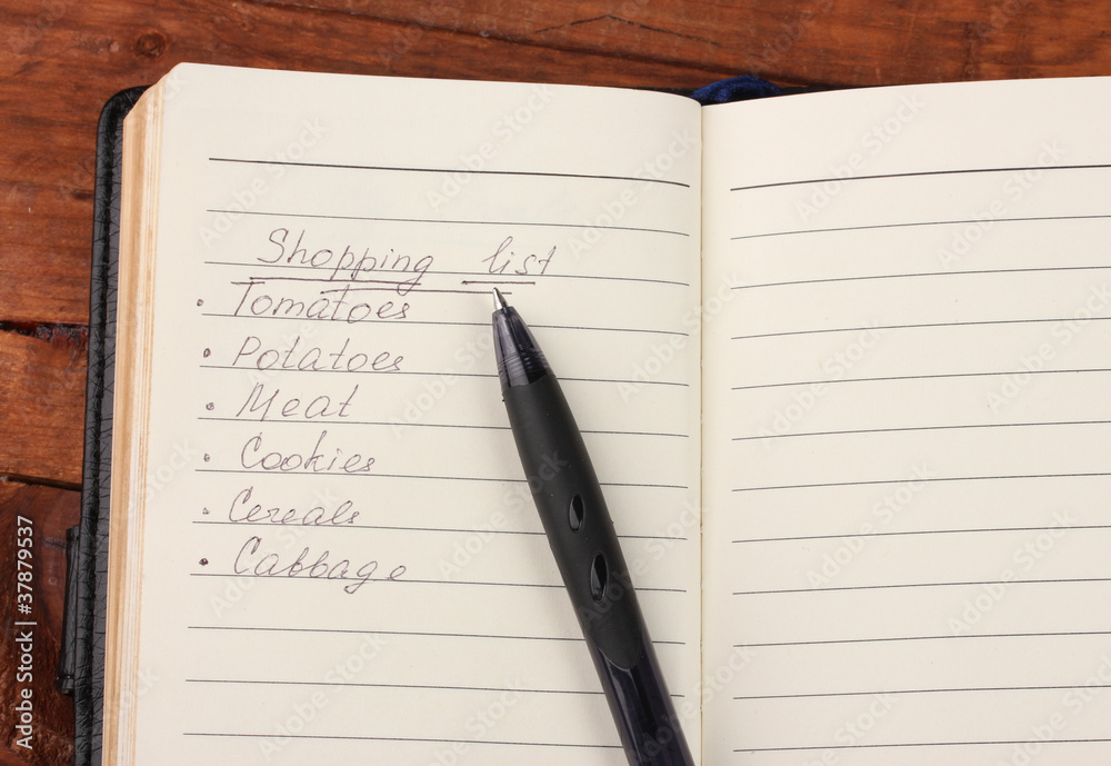 Shoping list and pen on wooden table Shoping list and pen on wooden table