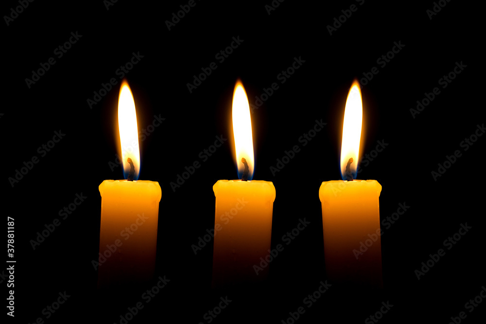 Three candles with flame over black background Three candles with flame over black background
