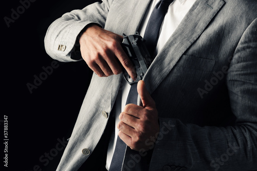 secret-agent guy  holding a gun  black background