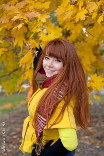 Pretty red haired young woman in autumn park