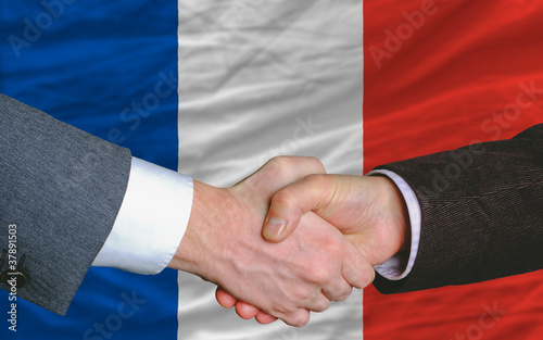 businessmen handshake after good deal in front of france flag photo