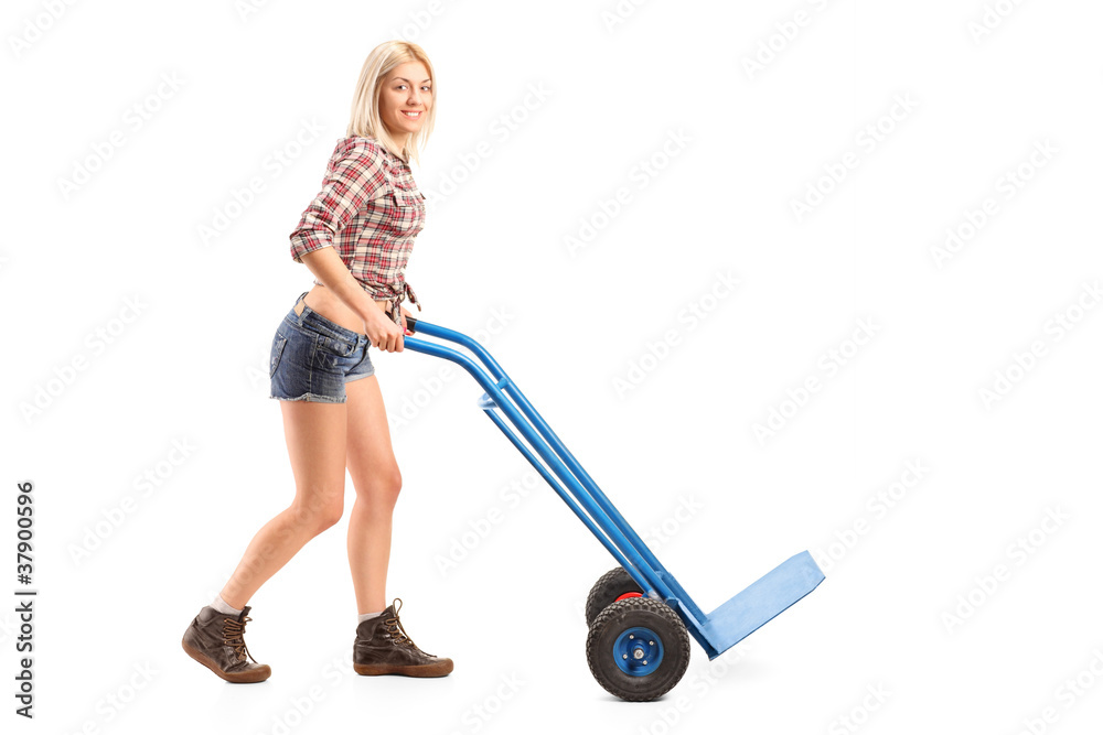 Female manual worker pushing an empty handtruck Female manual worker pushing an empty handtruck
