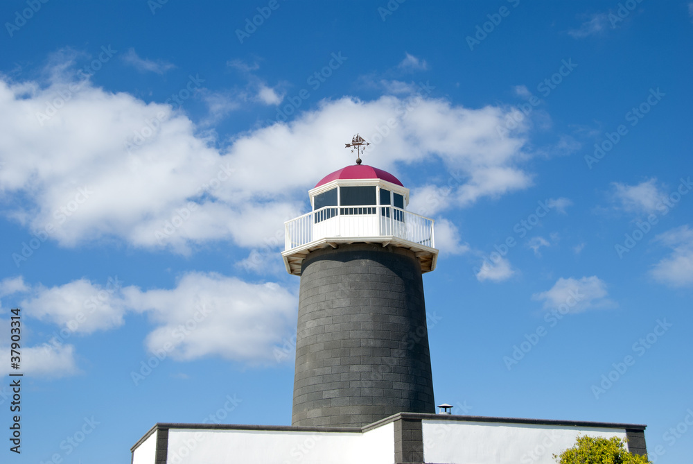 An Old Lighthouse with a sailing ship Weathervane