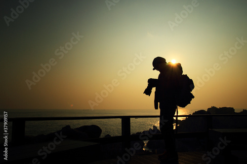Photography Man is taking a picture from the sunrise on the island and revie