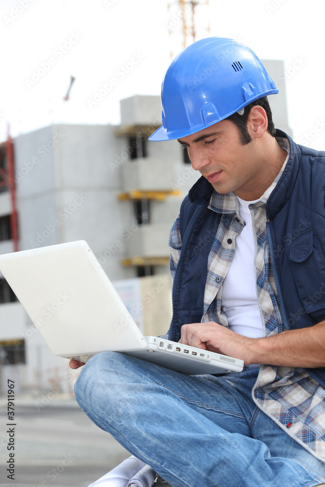 A foreman checking his laptop onsite. A foreman checking his laptop onsite.