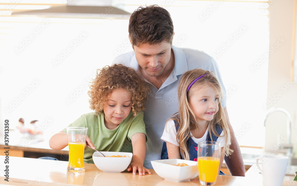 Young father with his children having breakfast