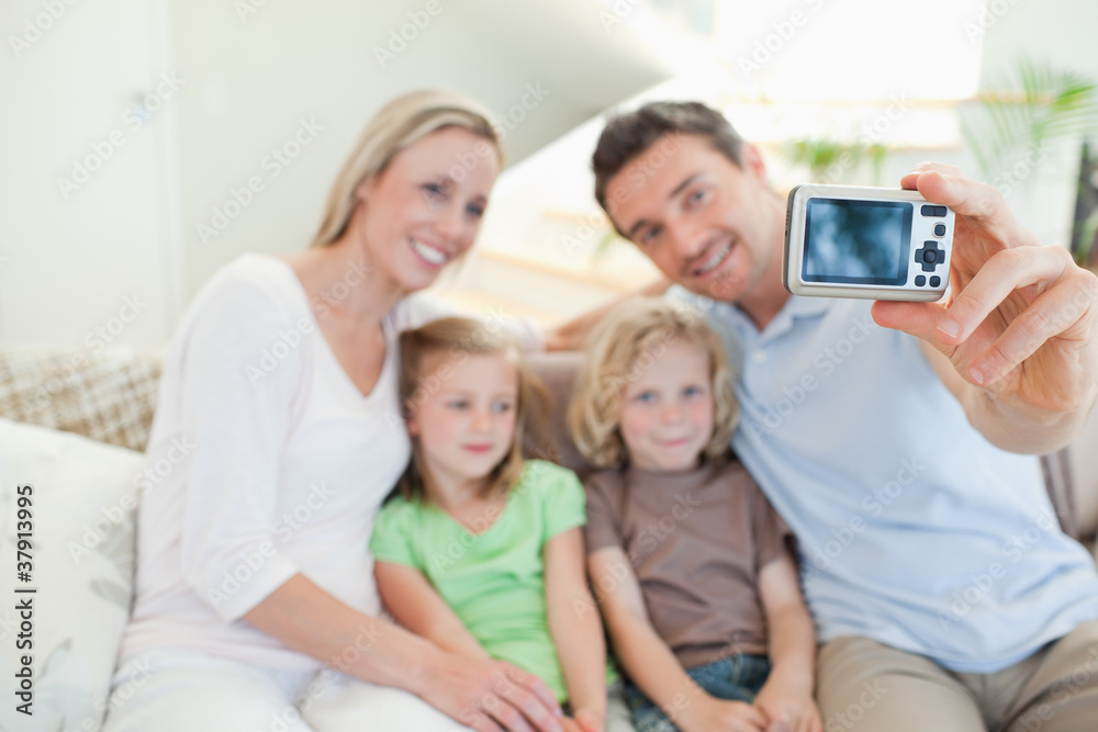 Father taking family picture on couch