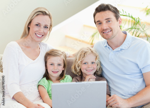 Family with laptop on the sofa