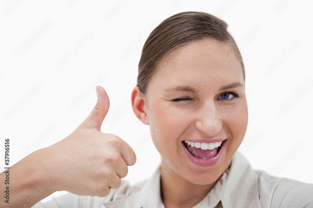 Businesswoman with the thumb up while winking Businesswoman with the thumb up while winking