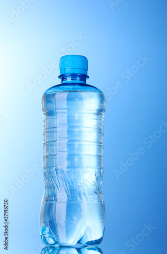Plastic bottle of water on blue background