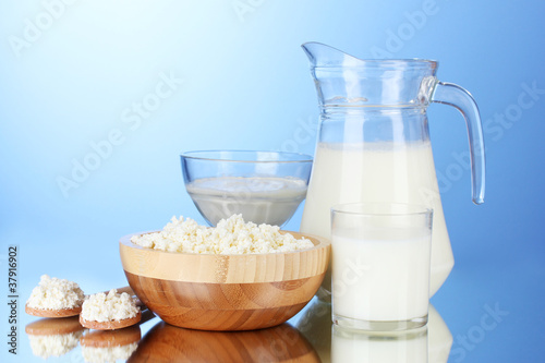 Milk, sour cream and cottage cheese on blue background