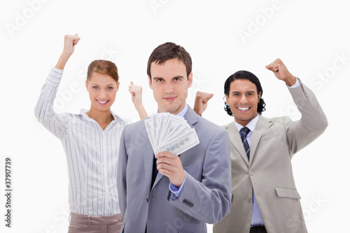 Businessman with cheering colleagues and money