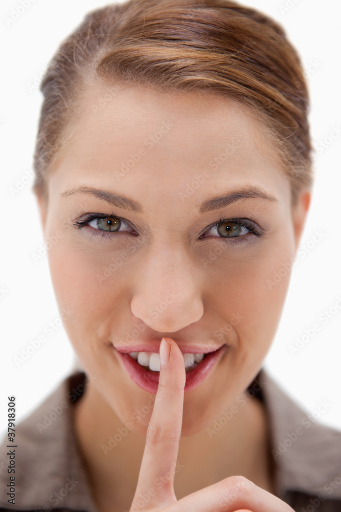 Smiling woman asking for silence Smiling woman asking for silence