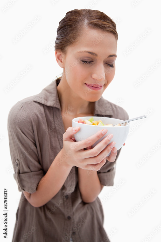 Woman smelling on her bowl of fruit salad Woman smelling on her bowl of fruit salad
