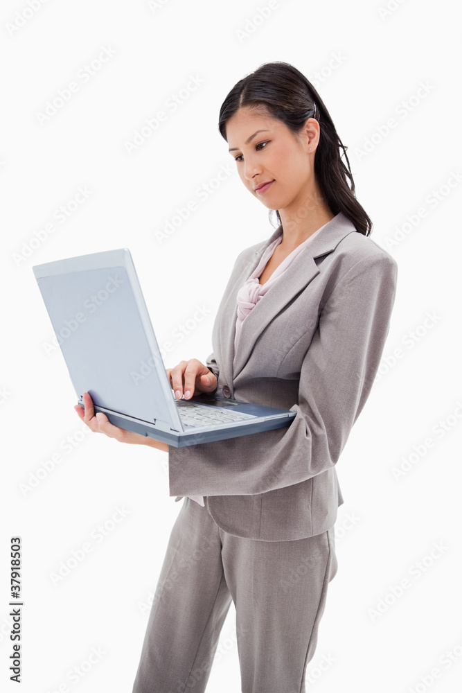 Side view of businesswoman standing with laptop Side view of businesswoman standing with laptop