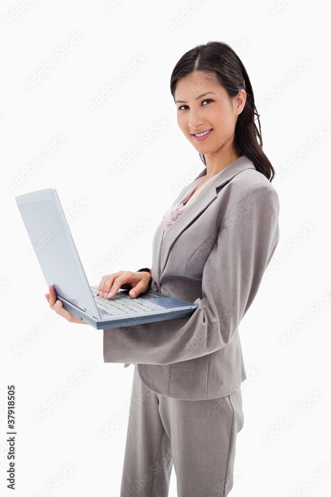 Side view of smiling businesswoman standing with laptop Side view of smiling businesswoman standing with laptop