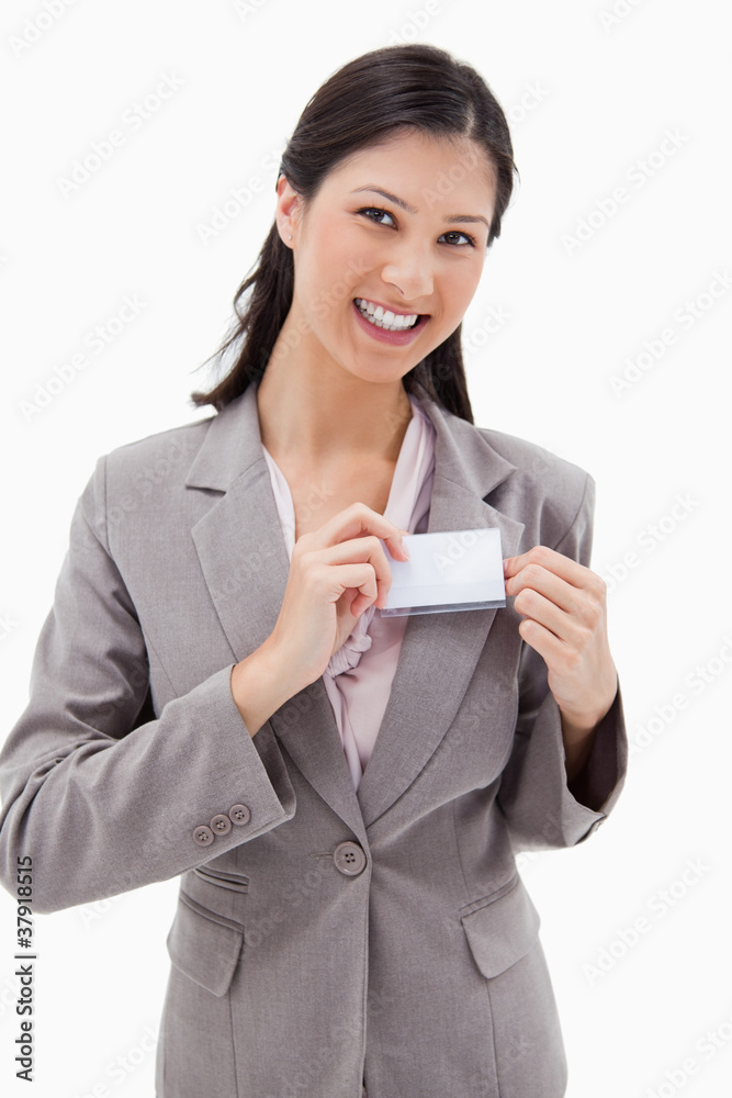 Smiling businesswoman putting on name badge Smiling businesswoman putting on name badge