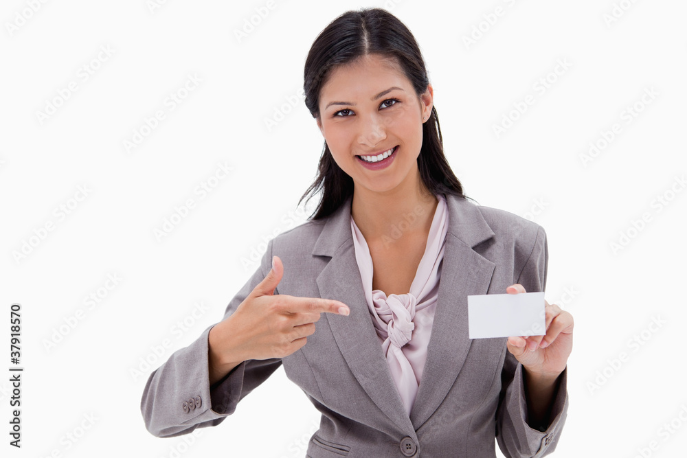 Smiling businesswoman pointing at blank business card Smiling businesswoman pointing at blank business card