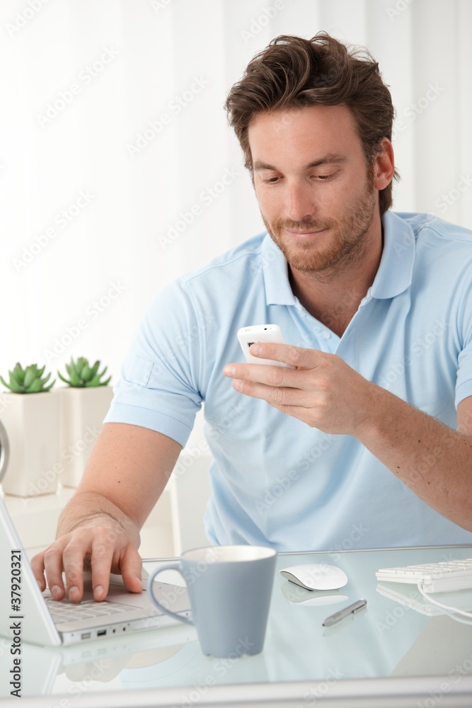 Smiling man texting on mobile phone Smiling man texting on mobile phone