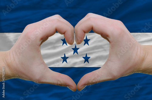 Heart and love gesture showed by hands over flag of honduras bac