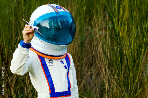 Fotografie child wearing astronaut helmet playing with toy airplane