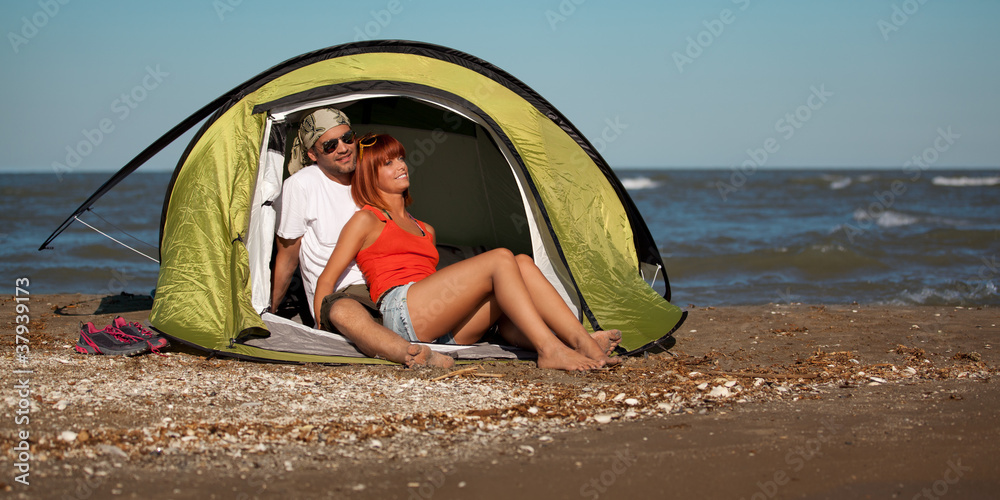 happy young couple sitting in tent seaside happy young couple sitting in tent seaside