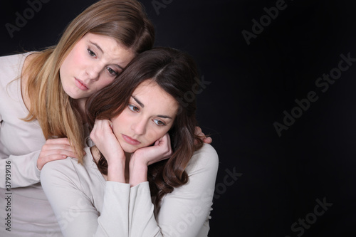 Young woman trying to comfort her friend photo