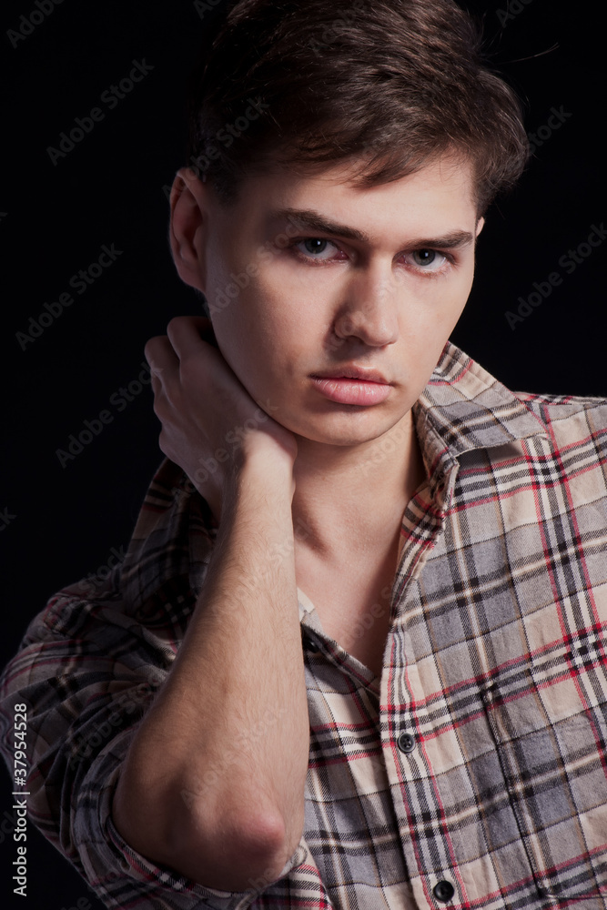 Portrait of a handsome young man in a plaid shirt