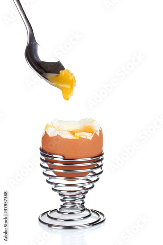 boiled egg in metal stand and spoon isolated on white