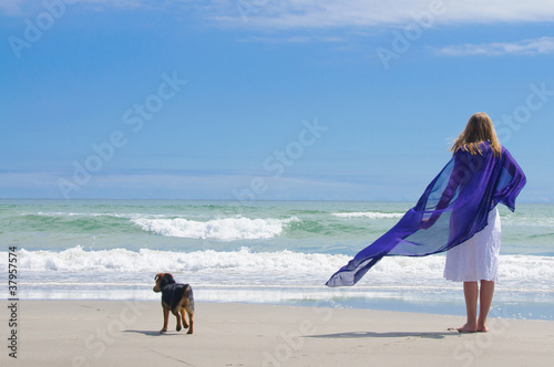 Girl at tbeach with dog photo