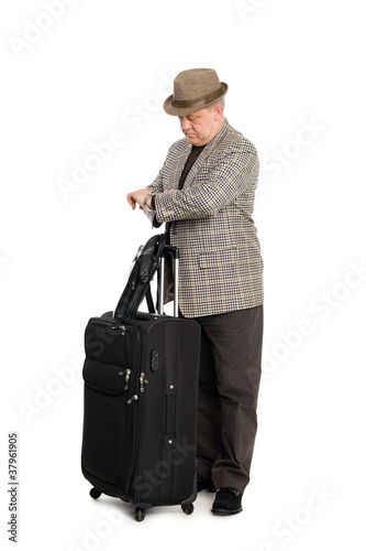 Traveler with luggage looks at his watch