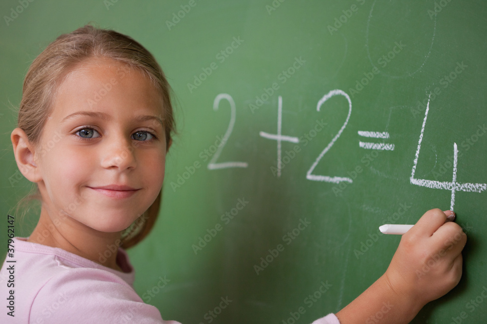 Smiling schoolgirl writing a number Smiling schoolgirl writing a number