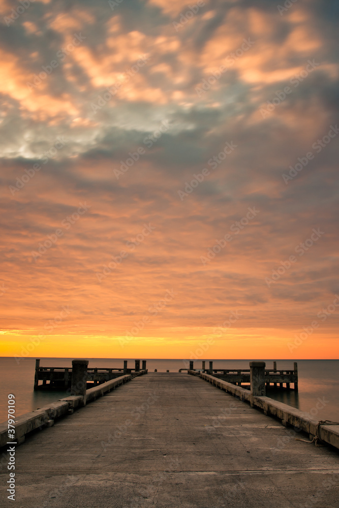Dramatic golden cloud and pier