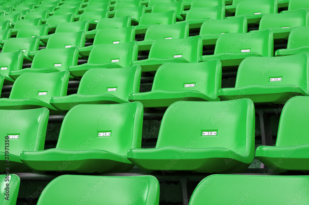 Naklejka premium Green Empty plastic seats at stadium