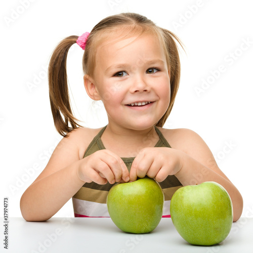 Little girl with two green apples