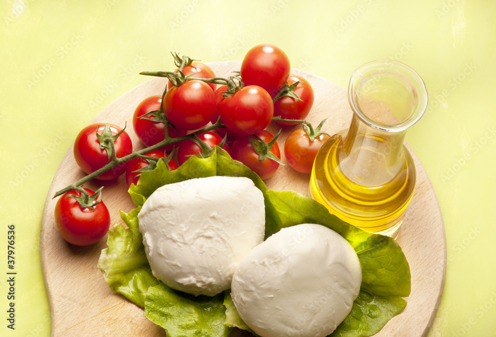 mozzarella and tomato cheries on green background