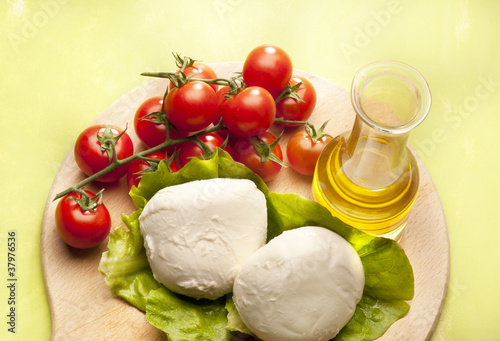 mozzarella and tomato cheries on green background