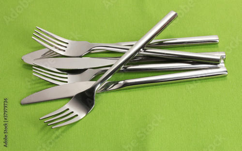 Forks and knives on a green tablecloth © Africa Studio